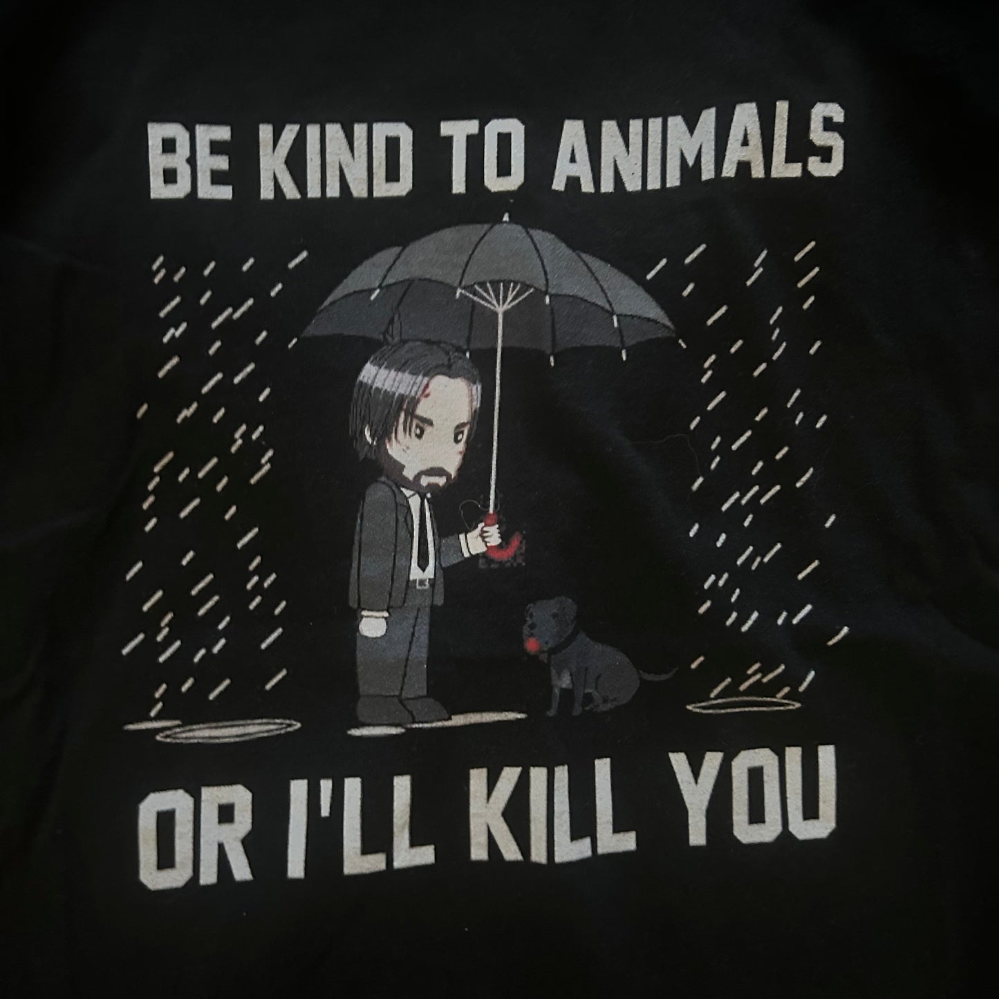 Black t-shirt with graphic design and text 'Be kind to animals or I'll kill you' on a dark background