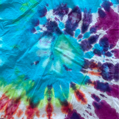 Close-up of a tie-dye tee shirt with vibrant colors including blue, green, red, and purple.