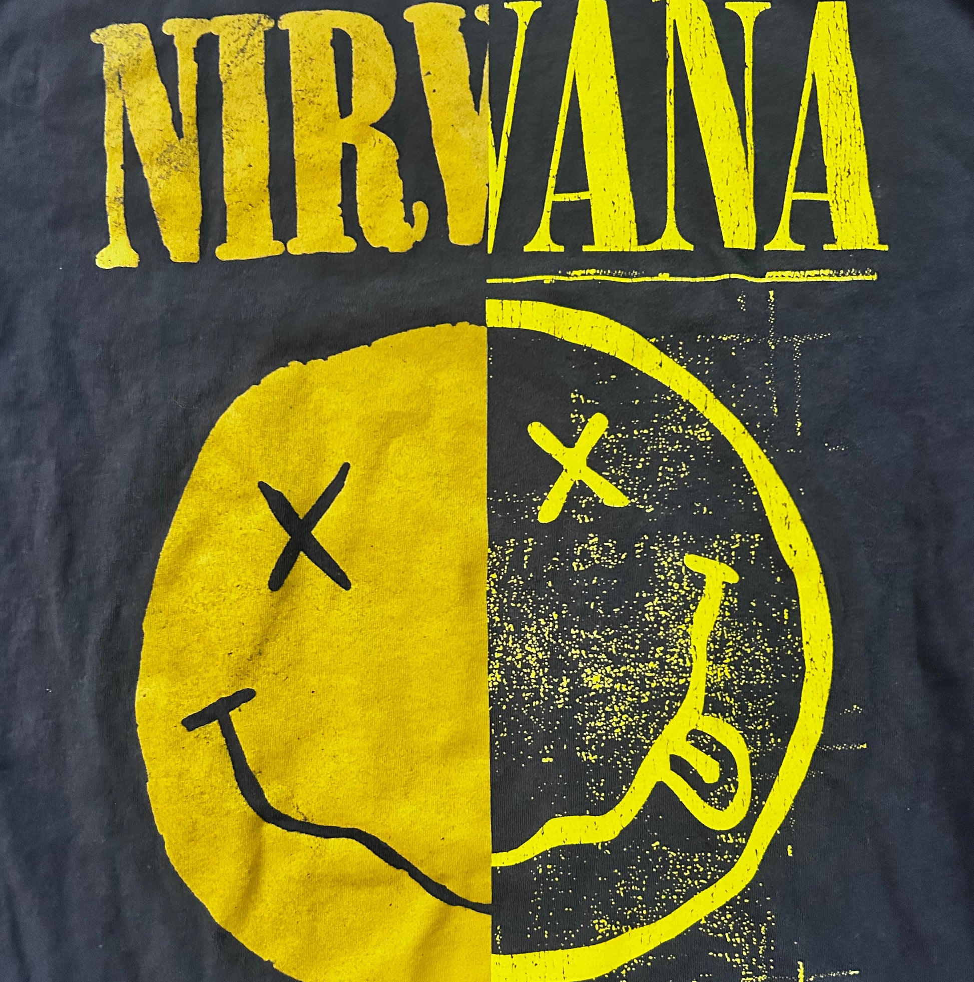 Nirvana logo with yellow text and graphic on a dark background 90s style
