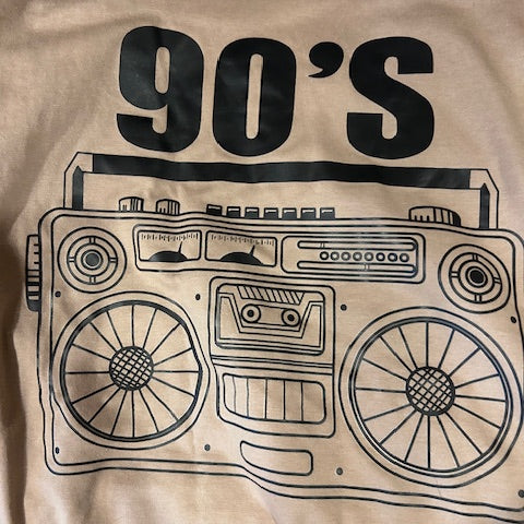 Beige tee shirt with a black graphic of a cassette tape and '90s' text with a boombox